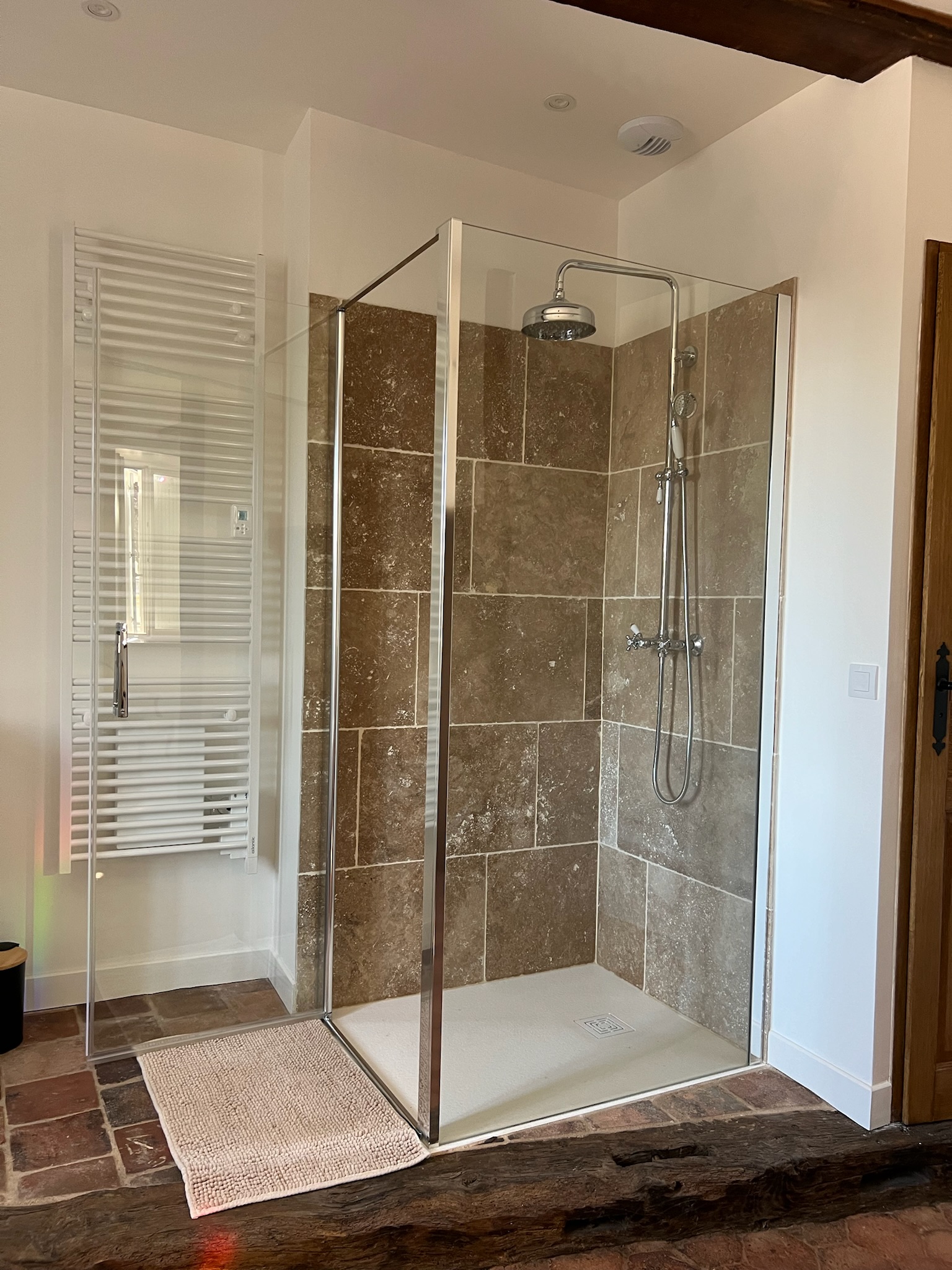 Salle de bain avec baignoire ancienne et douche à l’italienne